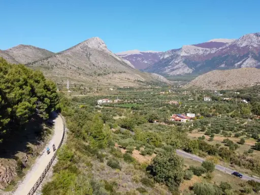 Ciclovia dei parchi Calabria: due ciclisti percorrono un sentiero panoramico tra uliveti e montagne.