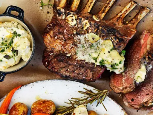 Grilla lamm med vitlök och örter, serverat med krämig potatisröra, rostade rotfrukter och grillad citron. En festmåltid!