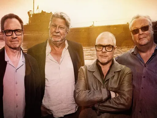 Fyra män står framför ett fartyg. En av dem är Rolf Lassgård, känd från en serie på SVT.