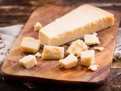 Parmesan-Stücke auf Holzbrett. So einfach kann parmesan einfrieren sein, um den Geschmack zu bewahren.