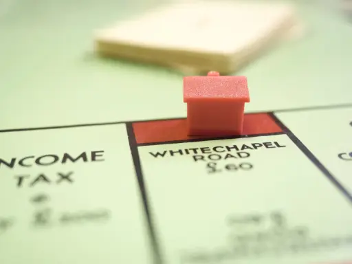 Une petite maison rouge sur le plateau Monopoly, près de Whitechapel Road. Le jeu simule le transfert de prêt.