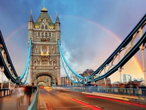 Tower Bridge in London, a city renowned for its art, glows under a double rainbow at dusk.