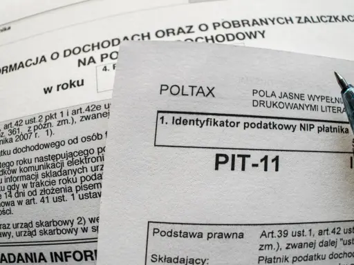 Formularz PIT-11, kluczowy do zrozumienia, jak wypełnić PIT-11 dla pracownika. Widoczny długopis sugeruje bieżące wypełnianie.
