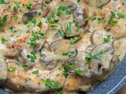 Polędwiczki w sosie pieczarkowym, kremowe i aromatyczne, posypane świeżą natką pietruszki.