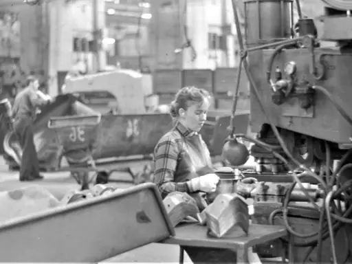 Kvinna arbetar vid maskin i fabriken, en del av arbetskraftsinvandring Sverige 1960.