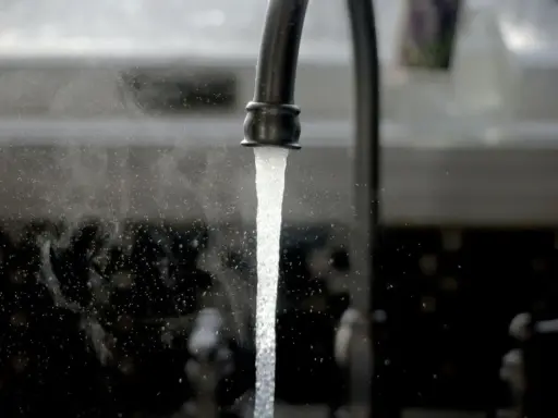 Un robinet ouvert, l'eau coule. Une image symbolisant l'ouverture du compteur d'eau pour un locataire.