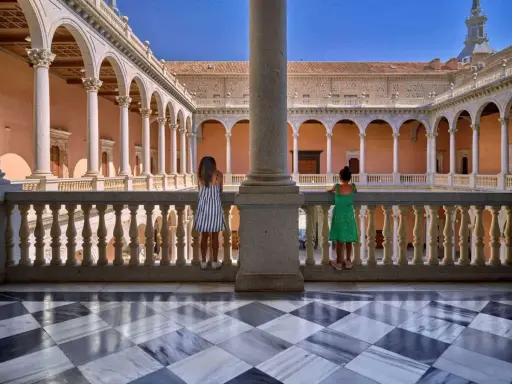 Dos niñas contemplan la arquitectura de un patio toledano. ¿Qué hacer hoy en Toledo? Explorar este lugar histórico.