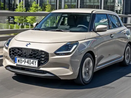 Nowy Suzuki Swift w beżowym kolorze, z nowoczesnym grillem i światłami LED. Sprawdź aktualne suzuki swift - ceny i oferty.