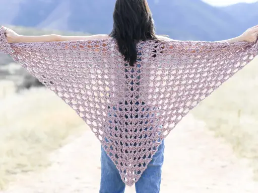 Chal triangular de crochet en tono rosa pálido, ideal para un patrón chal crochet facil.