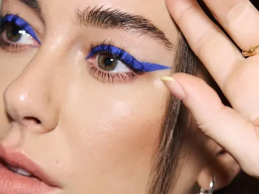 Ojos azules y piel blanca realzados con un audaz delineado azul eléctrico.