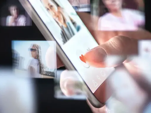 Palec przesuwa po ekranie smartfona, wybierając potencjalnych partnerów w aplikacjach randkowych.