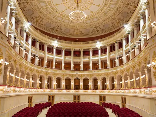 Interni sfarzosi del teatro Amintore Galli, con poltrone rosse e decorazioni dorate. Scopri i prossimi eventi!