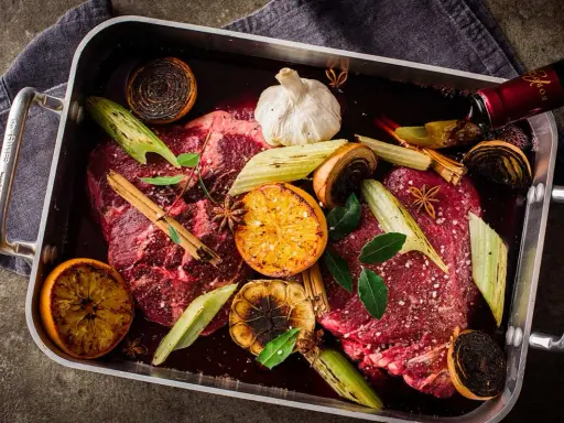 Råstekta köttbitar med apelsin, lök, vitlök och stjärnanis i en form. Ett perfekt minutfile recept för en festmåltid.
