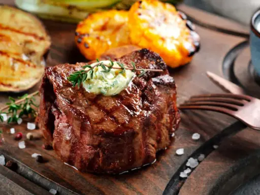 Perfekt gegrilltes Fleisch mit Kräuterbutter, dazu gegrilltes Gemüse und eine Dip-Schale.