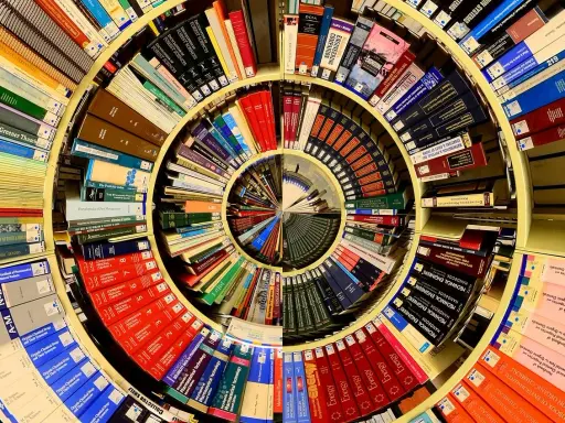 Książki ułożone w spiralę, tworząc piotr kościelny dom wiedzy. Widać tytuły o naukach ścisłych i przyrodniczych.