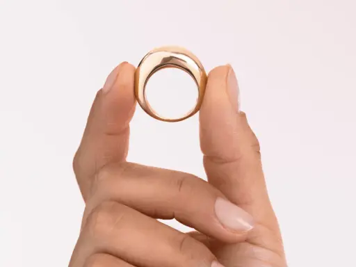 Dita che mostrano un anello in oro 18k 0.750, un gioiello elegante e moderno.
