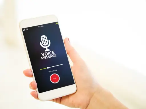Dyktafon w telefonie nagrywa wiadomość głosową. Ikona mikrofonu i przycisk "Stop" są widoczne na ekranie.