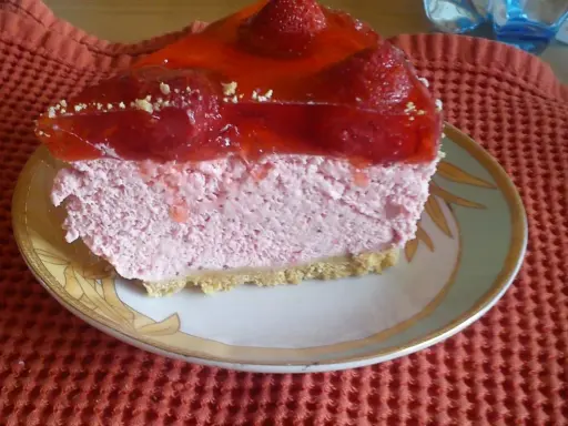 Pyszna pianka truskawkowa z galaretką i owocami, podana na talerzyku.