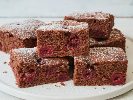Saftiger schoko kirsch kuchen blech, bestäubt mit Puderzucker. Ein Genuss für jeden Anlass!