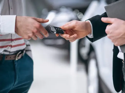 Un hombre entrega las llaves de un coche para una tasación de vehículo.