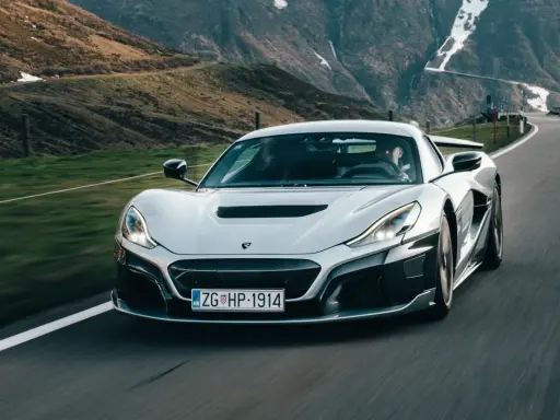 Silberner Rimac Nevera rast auf einer Bergstraße. Der Rimac Nevera Preis ist hoch, aber die Leistung ist unübertroffen.