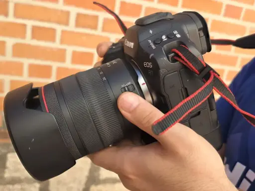 Mano sosteniendo una cámara Canon R1 con lente, lista para capturar momentos.