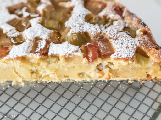 Pyszna babka z rabarbarem, posypana cukrem pudrem, idealna do pieczenia w temperaturze 180°C.