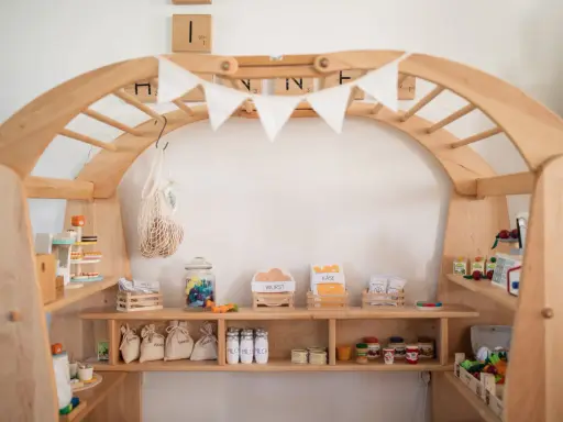 Ein liebevoll gestalteter Kaufladen zum selber bauen, gefüllt mit Spielzeug-Lebensmitteln wie Wurst, Käse, Zucker und Milch.