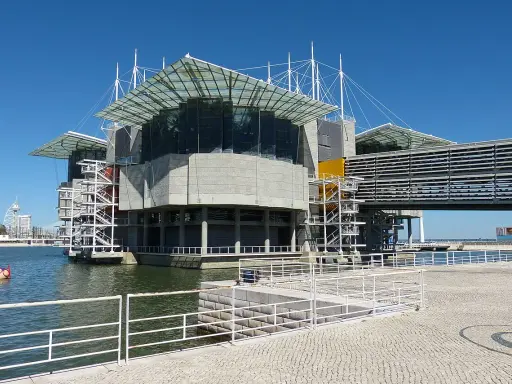 Das moderne Aquarium Lissabon ragt mit seinen Glasdächern und Betonstrukturen über dem Wasser auf.