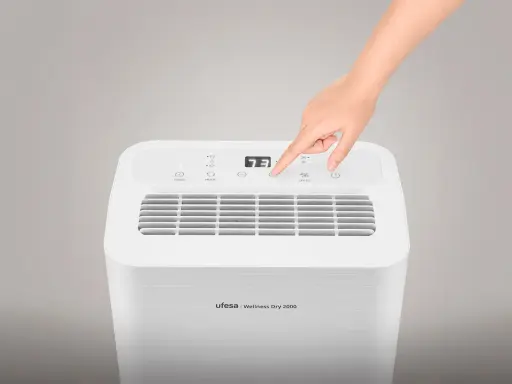 Mano ajustando la velocidad en un deshumidificador Ufesa Wellness Dry 2000. Guía para saber como elegir un deshumidificador.