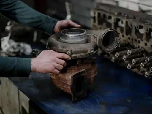 Mechanik trzyma turbosprężarkę, przygotowując się do wymiany zaworu N75.