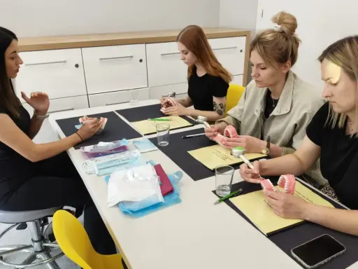 Uczestniczki kursu online dla higienistek stomatologicznych ćwiczą na modelach szczęk.