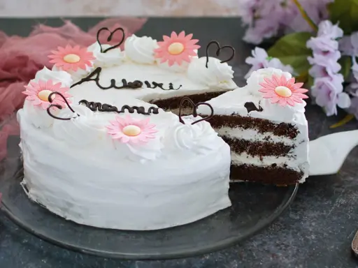 Torta decorata con fiori rosa e scritte in cioccolato, perfetta per la torta festa della mamma. Un dolce per celebrare con amore.