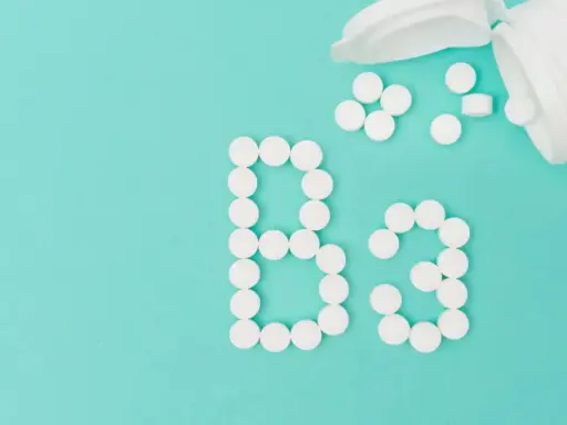 Des pilules blanches forment le "B3" sur fond turquoise. La vitamine B3, c'est quoi ? C'est essentiel pour votre corps.