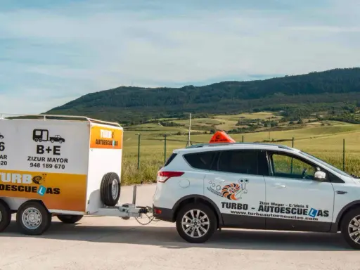 Coche blanco de autoescuela Turbo con remolque. Preparados para obtener el carnet B+E.