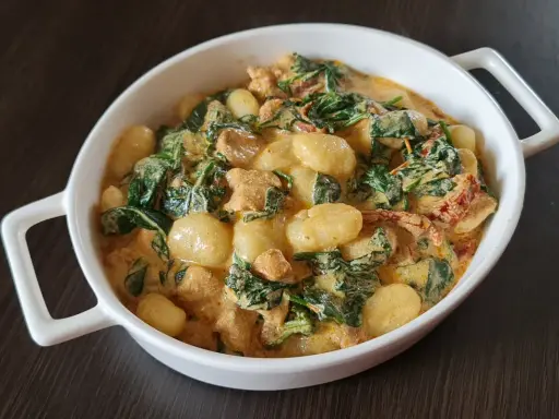 Pyszne gnocchi z kurczakiem w kremowym sosie ze szpinakiem i suszonymi pomidorami.
