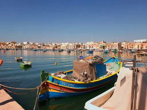 Färggranna fiskebåtar i hamnen, en dröm om att flytta till Malta.