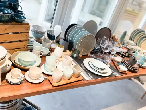 Vielfältiges Gastronomiegeschirr aus Keramik und Glas, darunter Teller, Schüsseln, Tassen und Gläser.
