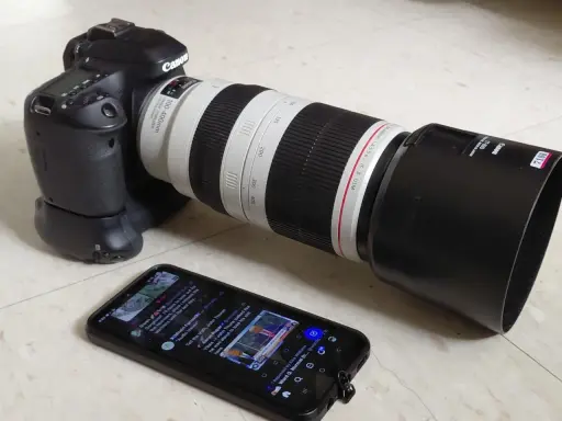Canon 80D con obiettivo 100-400mm, pronto per una recensione. Sullo smartphone, un tweet su politica.
