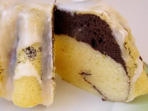 Pyszna babka gotowana z przepisu na ciasto dwukolorowe, polana lukrem.
