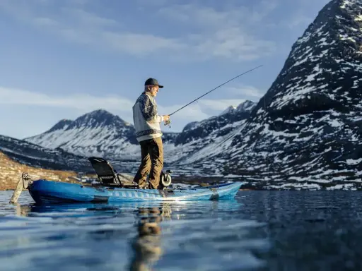 Man fiskar från en kajak i en fjällsjö. Frågan är hur långt paddlar man på en dag i sådan vacker natur?