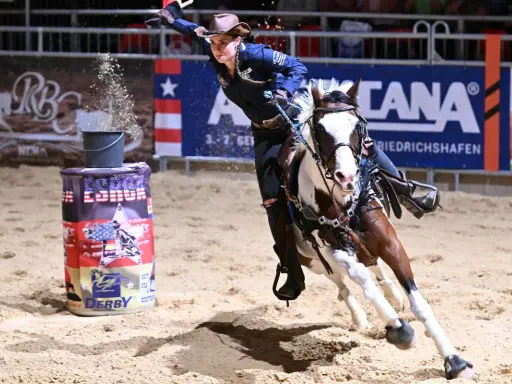 Reiterin im schnellen Galopp um eine Tonne beim Americana Friedrichshafen.