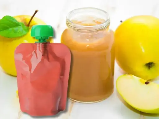 Jabłkowe puree w słoiczku i saszetce, idealne jako soki dla niemowląt od 3 miesiąca. Obok świeże jabłka.