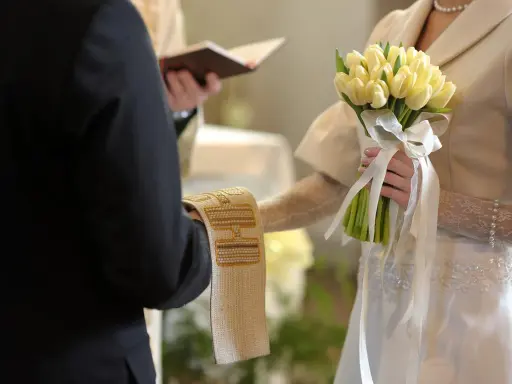 Para młoda trzyma bukiet żółtych tulipanów. Ceremonia ślubna, czy w adwencie można robić wesele?