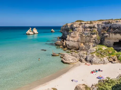 Spiaggia con scogli e mare cristallino, un angolo di paradiso in Puglia dove andare al mare.