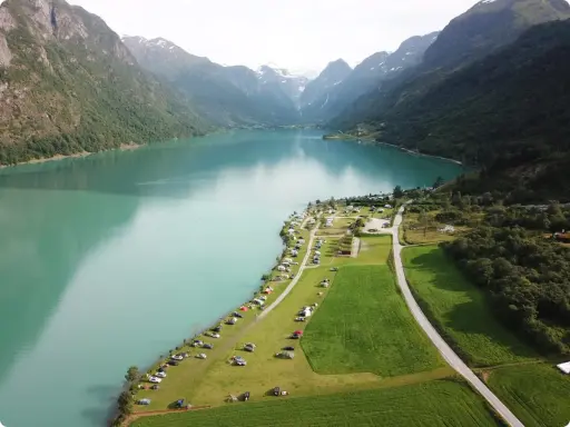 Vacker vy över en sjö med berg och campingplatser i Norge. Perfekt för dig som söker campingplatser Norge.