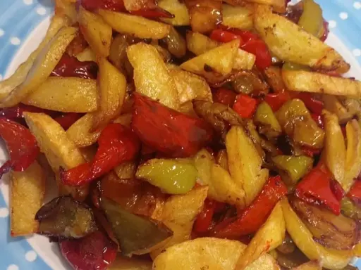 Patate fritte croccanti e peperoni colorati, un contorno saporito che ricorda la semplicità delle pipi e patate fatte in casa.