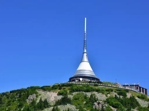 Wieża telewizyjna Ještěd, jedna z głównych libereckich atrakcji, góruje nad zielonym wzgórzem.