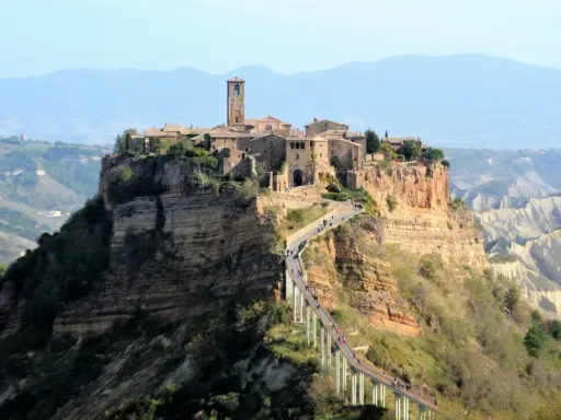 Civita di Bagnoregio, un borgo arroccato su una rupe, è uno dei posti da visitare in Italia. Un ponte pedonale collega il paese alla terraferma.