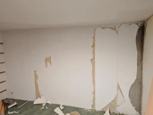 Renovierungsarbeiten: Alte Tapete wird entfernt, um die Wand für neues **Styropor tapezieren** vorzubereiten.